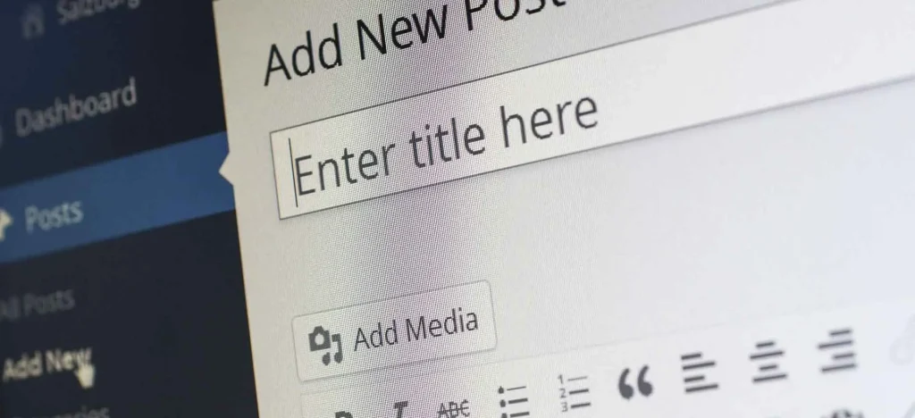 Zbliżenie na ekran edytora WordPress podczas tworzenia nowego wpisu, z widocznym polem na tytuł i opcją dodawania mediów, symbolizujące proces publikacji treści na stronie internetowej za pomocą systemu CMS.