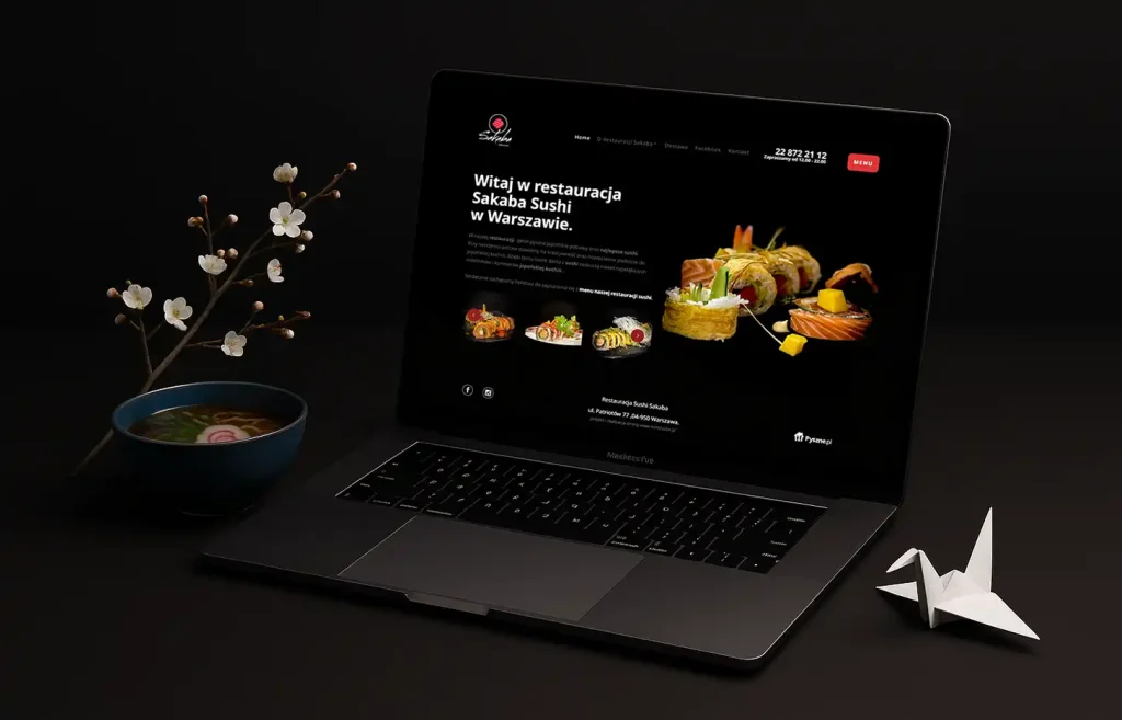 Mockup strony restauracji Sakaba Sushi w Warszawie na laptopie z japońską dekoracją i sushi na czarnym tle